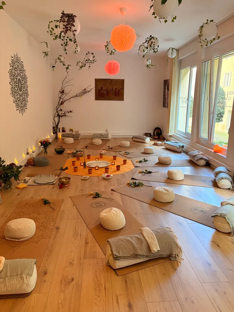 The studio set up for a ceremony, mats arranged around a warm centre circle of candles and flowers