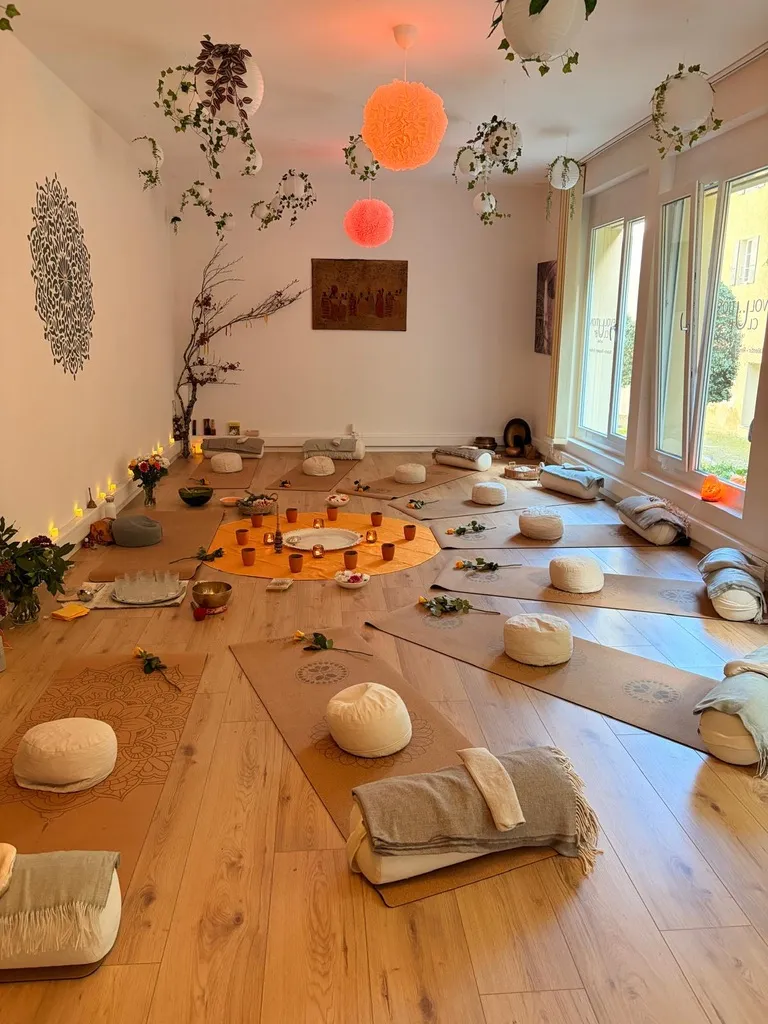 The studio set up for a ceremony, mats arranged around a warm centre circle of candles and flowers