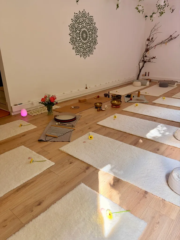 Sunlight falling across white mats laid out for a sound journey